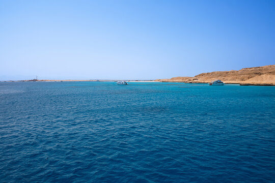 Scenic coral reef in turquoise ocean water near desert coastline