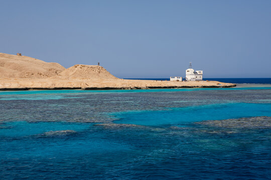 Scenic coral reef in turquoise ocean water near desert coastline