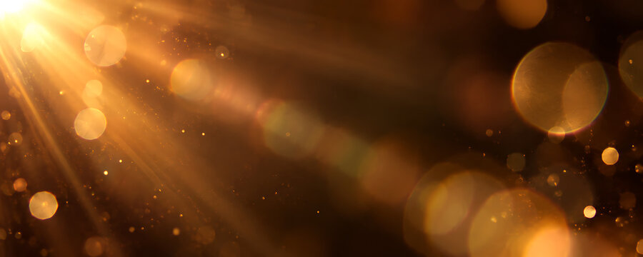 Warm sun flare with glowing golden bokeh orbs and dust particles