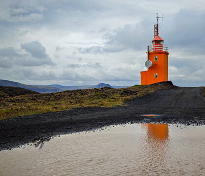 Hopsnes Orange Lighthouse Reflected in Water Puddle