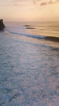 Drone view with breaking ocean waves in ocean in Bali