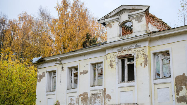Weathered old building showing the effects of time, with peeling paint, eroded plaster, cracked walls and deteriorating architectural details. Aging materials, gradual decay.