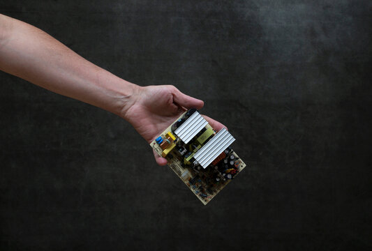 Male hand handing over a computer circuit board