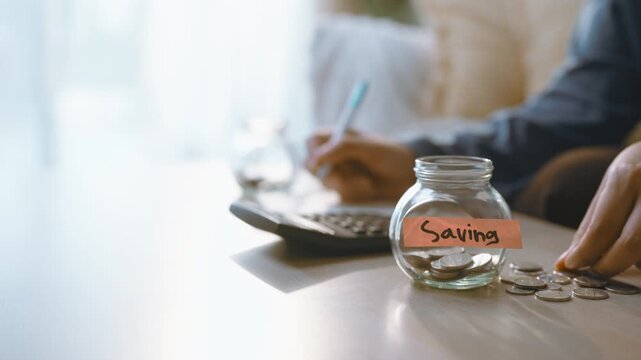 A savings contribution drops into a jar as a hand repeats the coin deposit beside a calculator, with the jar carrying a saving label and each savings contribution showing a regular saving habit.