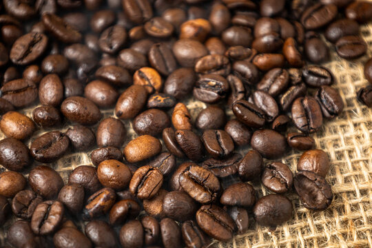 Close-up of roasted coffee beans on rustic burlap sack