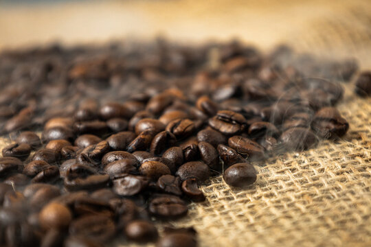 Close-up of roasted coffee beans on rustic burlap sack