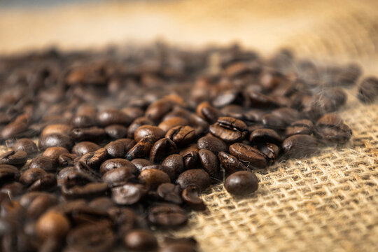Close-up of roasted coffee beans on rustic burlap sack