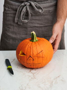 Pumpkin carving preparation with artistic expression and knife, Halloween celebration craft