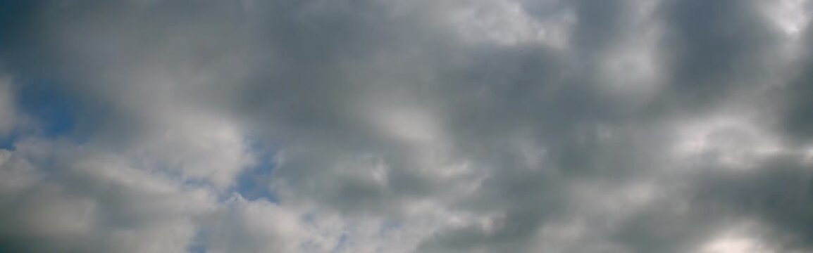 Cinematic anamorphic timelapse of storm clouds and patches of blue sky