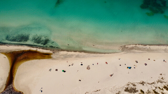 Breathtaking aerial view of pristine white sand beach meeting vibrant turquoise ocean waters alongside a winding river mouth creating a harmonious tropical paradise landscape for summer vacations