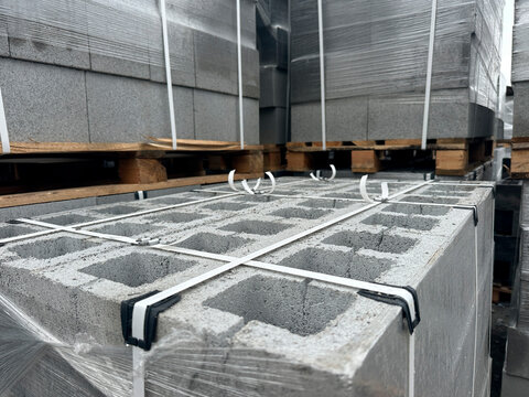 Stacked and wrapped pallets of concrete blocks outdoors