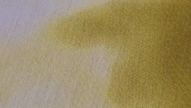 Close-up of woven fabric texture with a soft gradient transition from pale lavender to olive green, textile surface detail