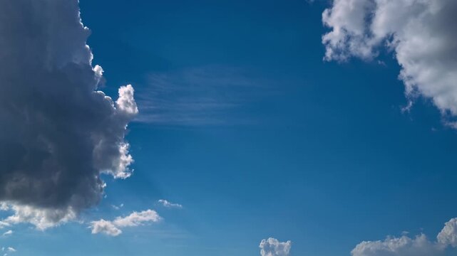 Sky timelapse. Moving clouds and sun. White fluffy clouds slowly float through the blue daytime sky timelapse. Beautiful skies are moving. White cumulus and cirrus.