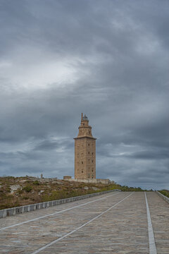 The Tower of Hercules stands majestically beneath a stormy sky.