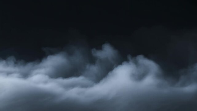 Dark storm clouds billow through layered mist across an open sky. Weather programming, storm warning graphics, and horror film atmosphere.
