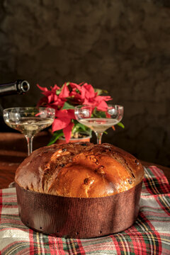 Panettone Christmas cake with sparkling wine and poinsettia for festive holiday celebration