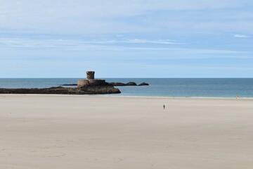 SAINT-OUEN, JERSEY - 10 SEPTEMBRE 2026 : La tour Martello fortifiée de Rocco (Rocco Tower) isolée sur son rocher au milieu de la plage de sable à marée basse. © stphanie