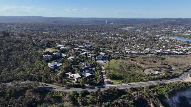 Aerial drone view over the township of Anglesea, Victoria, Australia, with the low-density residential community embedded within native eucalyptus bushland , the Great Ocean Road curves along cliffs.