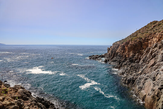Rugged Rocky Cliffs and Sea Kayakers at La Bufadora in Ensenada, Baja California, Mexico.