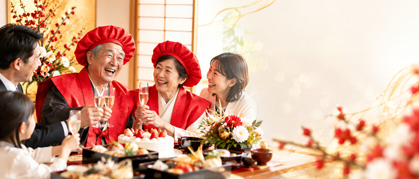 還暦を迎えた夫婦が赤い祝い着をまとい家族と笑顔で乾杯するお祝いの食卓