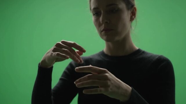 Person Demonstrating Hand Movements in Green Screen Studio