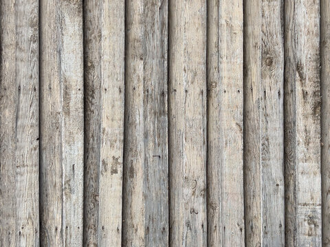 Weathered vertical wooden planks with faded gray beige tones, rough natural grain and rustic aged texture, forming a vintage wood background.