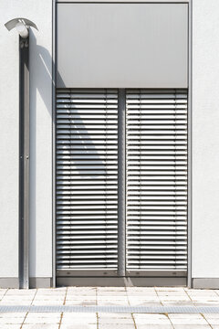Fenster mit verschlossener Jalousie als Sonnenschutz an einem B&uuml;rogeb&auml;ude