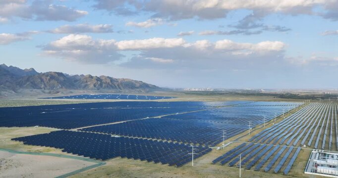 Aerial time-lapse of  vast solar photovoltaic power station with substation before Yinshan mountains, Bayannur, Inner Mongolia, China
