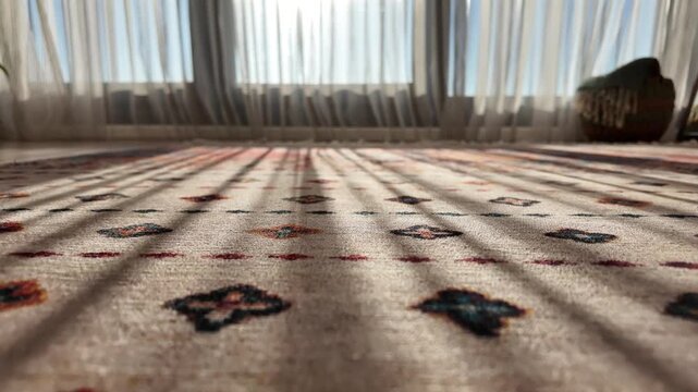 Morning sunlight falls across a patterned carpet beside a curtained window