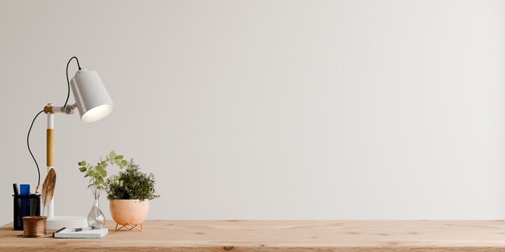 Wooden desk workspace with lamp potted plant notebook and empty wall background mockup- 3D rendering
