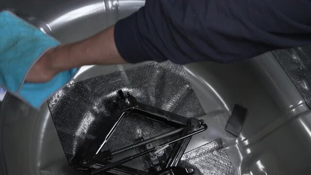 Scissor jack and crank handle stored in a car spare wheel well