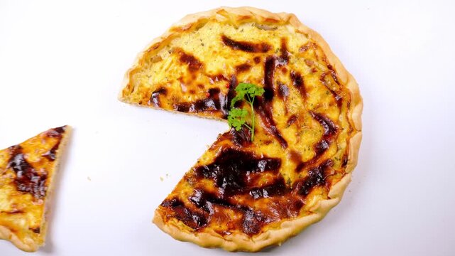Freshly baked quiche lorraine pie with slice served isolated on white background
