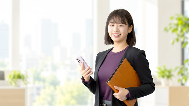 スマートフォンとバインダーを持つ女性・ビジネスウーマン