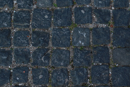 texture of grey, rough, paving stones road