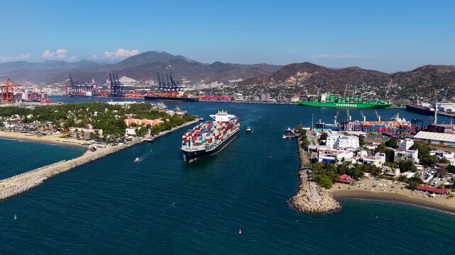 A highangle aerial shot showing a massive cargo vessel entering the industrial port of Manzanillo, Colima, surrounded by logistics infrastructure and coastal scenery.