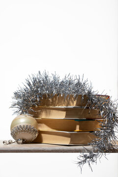 A stack of classic books draped in sparkling silver tinsel with a vintage bauble. ?? Ideal for elegant holiday bookstore promotions, winter reading gift guides, and sophisticated library displays.
