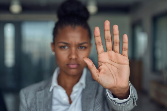 Upset office worker black woman making a "stop" gesture with her hand. No to violence in the office workplace