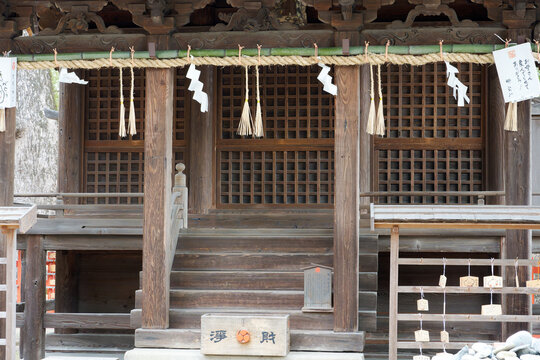 FUKUOKA, JAPAN - FEB 21, 2025: Traditional wooden shrine pavilion with shimenawa rope and votive messages for maternal gratitude at Umi Hachimangu Shrine in Fukuoka.