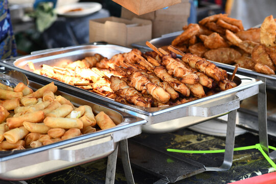 Fried Thai street food like spring rolls and chicken skewers