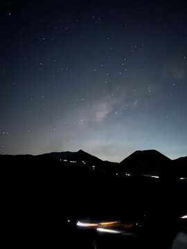 Stunning Milky Way galaxy stars in the night sky over the dark mountain silhouette of Mount Bromo Tengger Semeru National Park, East Java, Indonesia.
