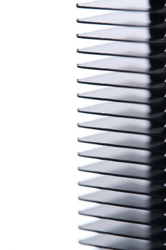 Close up black metal radiator fins aligned against clean white contrasting background.