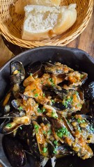 Steamed Mussels in Tomato Sauce and Bread in Wicker Basket © bloomingjourneys