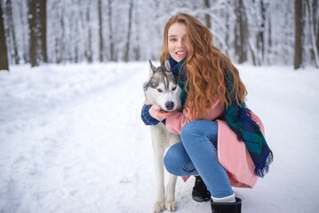 Young girl with hugging a husky dog in a winter forest © Nomad_Soul