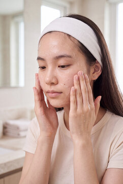 Young woman cleansing face with water wearing headband for skincare routine background and beauty banner design