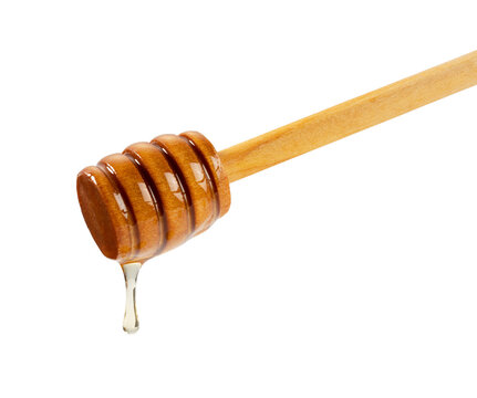 Honey dripping from wooden honey dipper wand isolated on transparent background