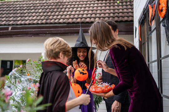 Multiracial children celebrating Halloween party together in house.