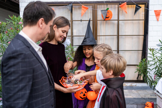 Multiracial children celebrating Halloween party together in house. 