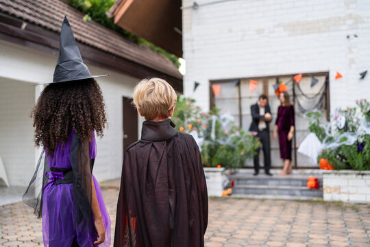 Multiracial children celebrating Halloween party together in house. 