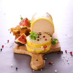 Gourmet foie gras slice on wooden board with fresh fig gingerbread and peppercorns © M.studio