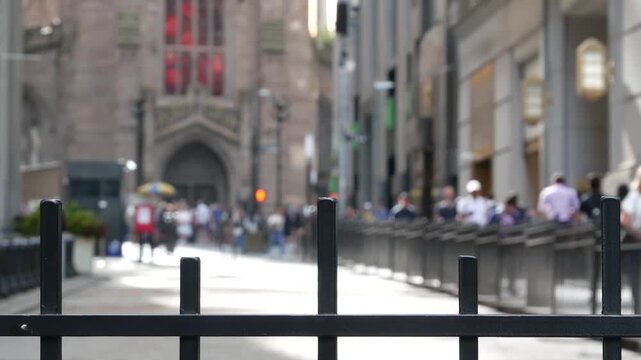Broadway in Manhattan Downtown Financial District, Trinity Church on Wall street, New York City, United States of America. People pedestrians, defocused office workers near Stock Exchange building.
